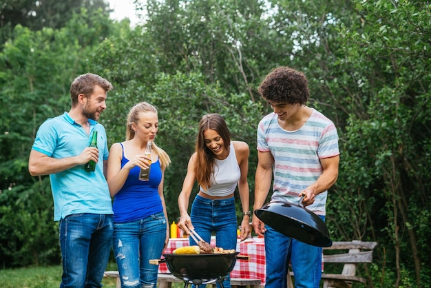 Freunde genießen den Picknicktag und grillen zusammen