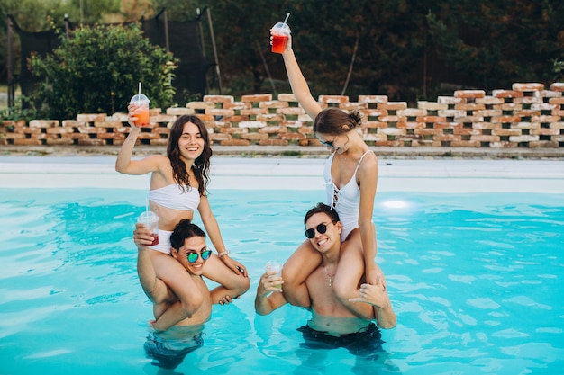 Freunde haben eine Party am Pool und genießen gemeinsam