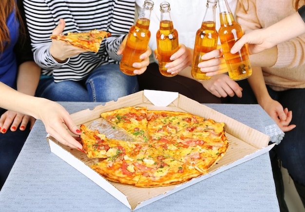 Freunde Hände mit Flaschen Bier und Pizza aus nächster Nähe