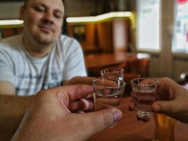 Foto freunde halten tequila-shots über dem tisch