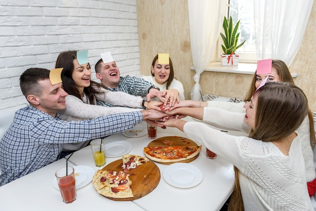 Freunde im Café essen Pizza und spielen raten, wer