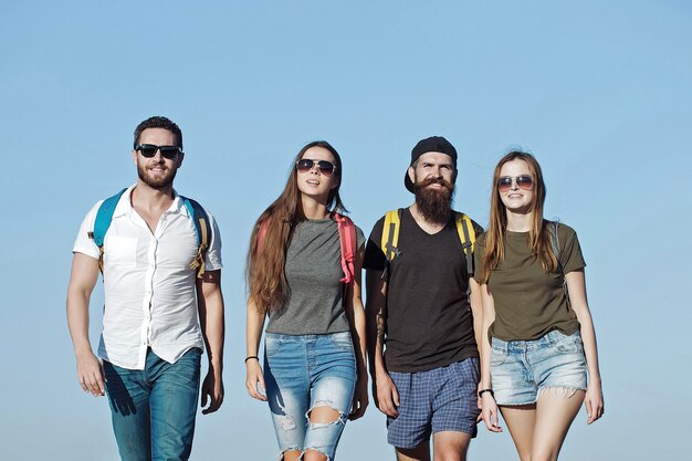 Freunde in Jeans und Shorts mit Rucksäcken im Freien