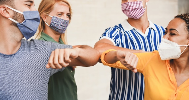 Foto freunde junger leute stoßen mit den armen, anstatt sie mit einer umarmung zu begrüßen. - vermeiden sie die verbreitung von coronavirus, sozialer distanz und freundschaftskonzept. - konzentrieren sie sich auf nahaufnahmen