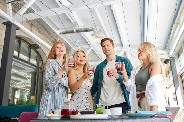 Freunde klirren Gläser über Esstisch im Restaurant