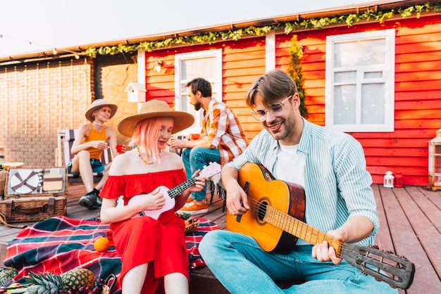 Freunde machen ein Picknick und spielen Gitarre