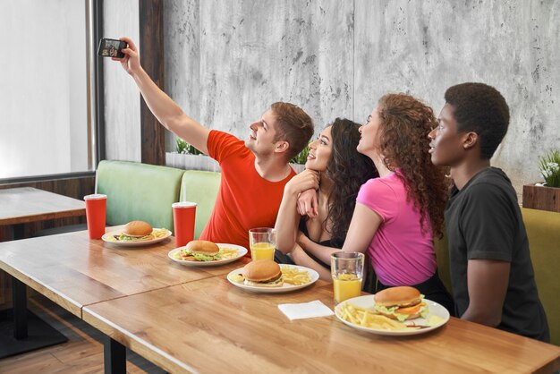 Freunde machen selfie am telefon im café.