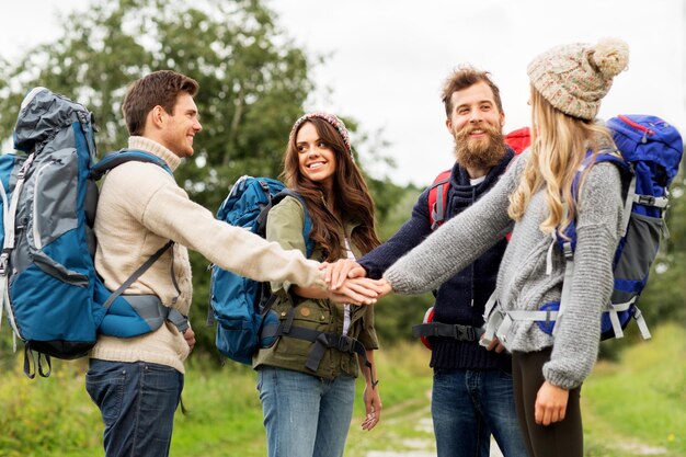 Foto freunde mit rucksäcken wandern und stapeln hände