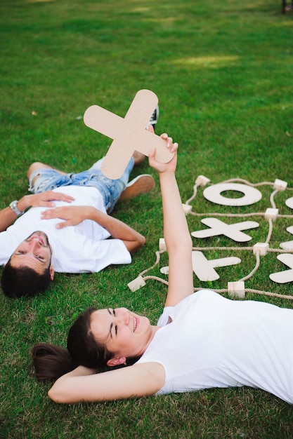 Freunde ruhen sich aus und spielen Tic-Tac-Toe-Spiel auf dem grünen Rasen.