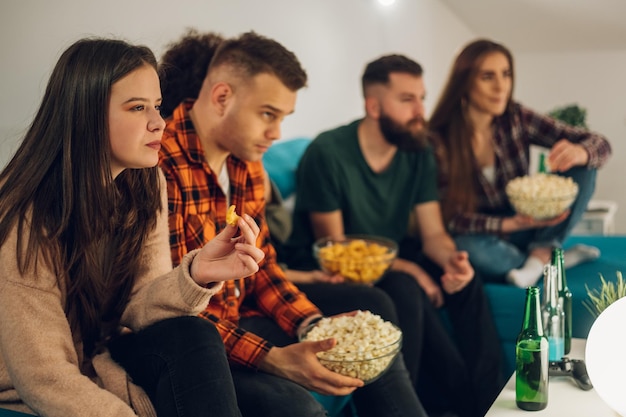 Freunde schauen sich zu Hause Filme an und essen Snacks