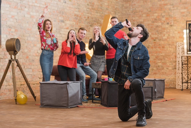 Freunde singen Karaoke auf einer Party