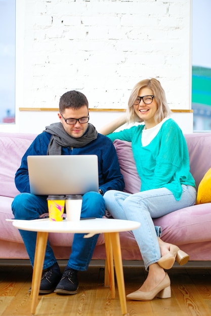 Freunde sitzen auf der Couch und unterhalten sich mit einem Desktop-Computer