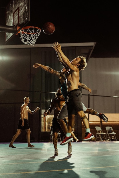 Freunde spielen Basketball. Junge Männer spielen Basketball auf der Straße.