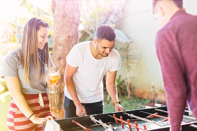 Freunde spielen Tischfußball im Freien