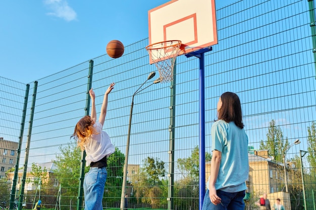 Freunde Teenager spielen Straßenbasketball Spielplatz im Freien