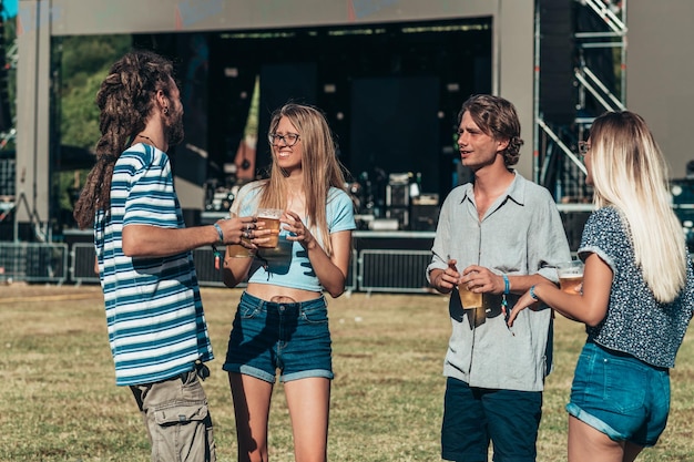 Freunde trinken Bier und haben Spaß beim Musikfestival