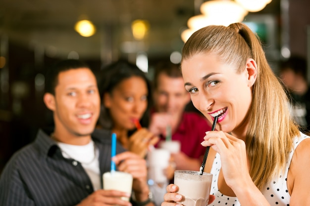 Freunde trinken Milchshakes in einer Bar