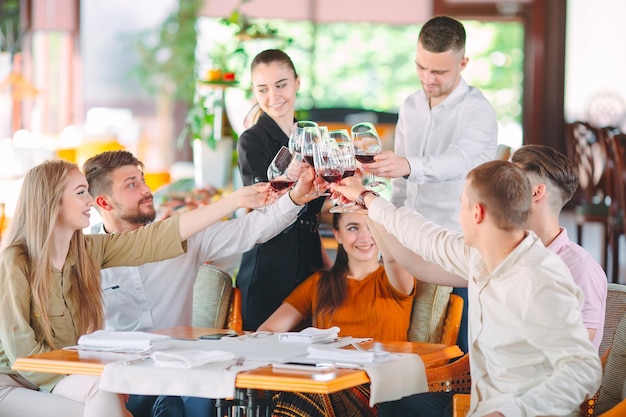 Freunde trinken Wein auf der Terrasse des Restaurants.