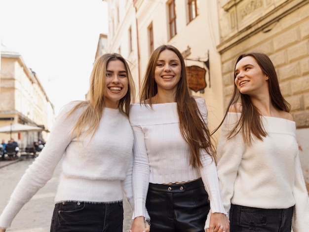 Freundinnen lachen, die in den Straßen der Stadt gehen