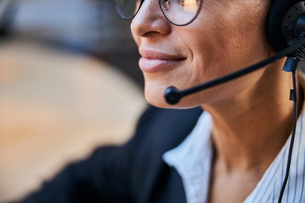 Freundliche dunkelhäutige Frau, die beim Online-Meeting Positivität ausdrückt