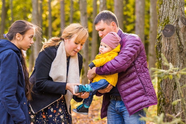 Freundliche Familie, die im Herbst zusammen im Park spazieren geht