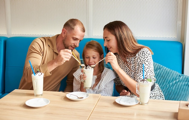 Freundliche Familie mit Milchshakes im Café