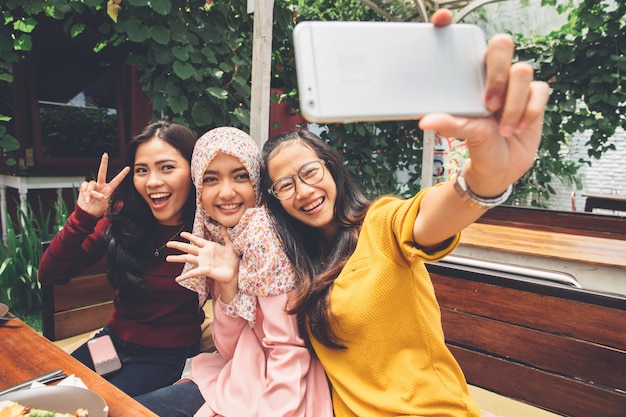 Freundliche Mädchen machen Selfie im Café