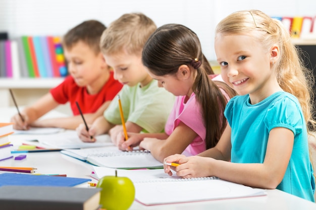 Freundliche Schulkinder auf unscharfem Hintergrund im Klassenzimmer