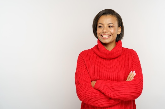 Freundliche schwarze Frau mit rotem Strickpullover glückliche afrikanische Frau in Wollpullover gekleidet