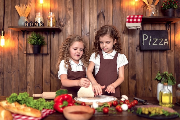 Freundliche Schwestern, die zusammen Pizza kochen