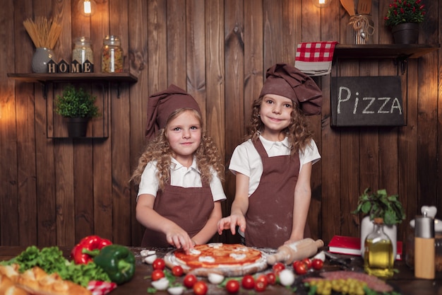 Freundliche Schwestern, die zusammen Pizza kochen