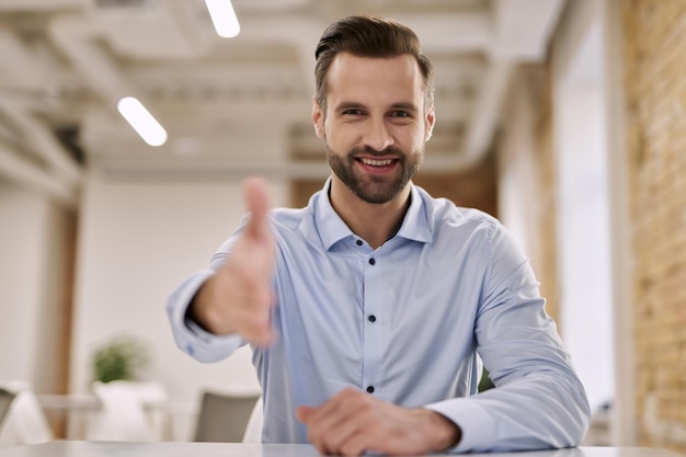 Freundlicher Manager, der seine Hand in einladender Geste gibt