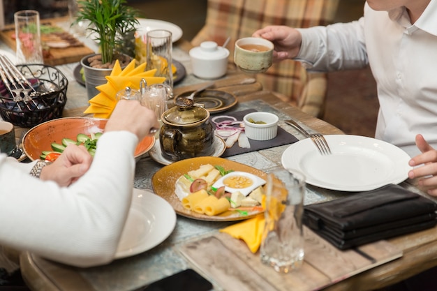 Freundliches Abendessen. Gruppe von Menschen, die zusammen zu Abend essen, während sie am Holztisch sitzen.