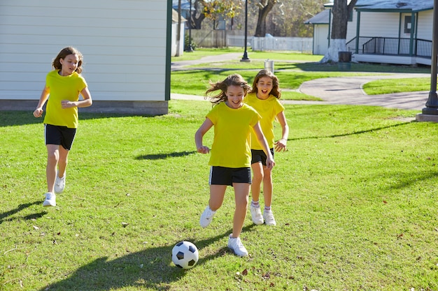 Freundmädchenjugendlich, der Fußballfußball in einem Park spielt