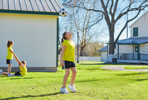 Freundmädchenjugendlich, der Fußballfußball in einem Park spielt