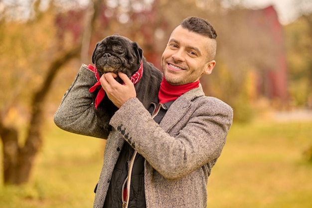 Freundschaft. Ein glücklich lächelnder Mann mit seinem Hund im Park