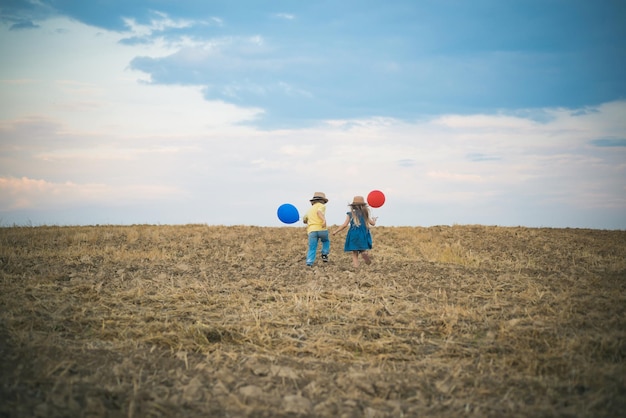 Freundschaft Kinder und Unterstützung Rückansicht Internationaler Tag der Freundschaft Zwei kleine Kinder spielen zusammen im Freien Sommerspaß-Urlaubskonzept