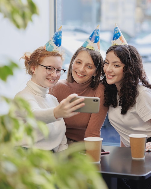 Freundschaft und Unterstützung Drei Frauen feiern ihren Geburtstag in einem Café-Restaurant und rufen an