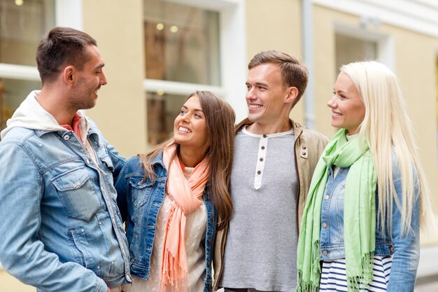 freundschafts-, reise- und urlaubskonzept - gruppe lächelnder freunde, die in der stadt spazieren gehen