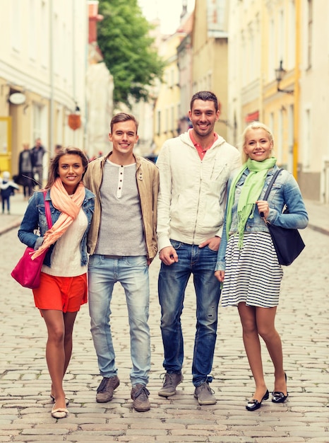 freundschafts-, reise- und urlaubskonzept - gruppe lächelnder freunde, die in der stadt spazieren gehen