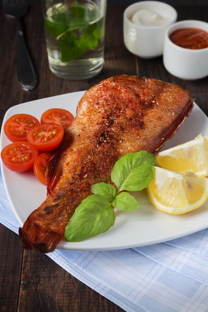 Fried Barsch mit Tomaten auf einem weißen Teller