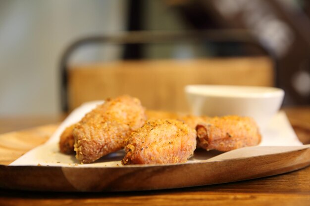 Fried Chicken Wings auf Holzhintergrund mit Restaurantlicht