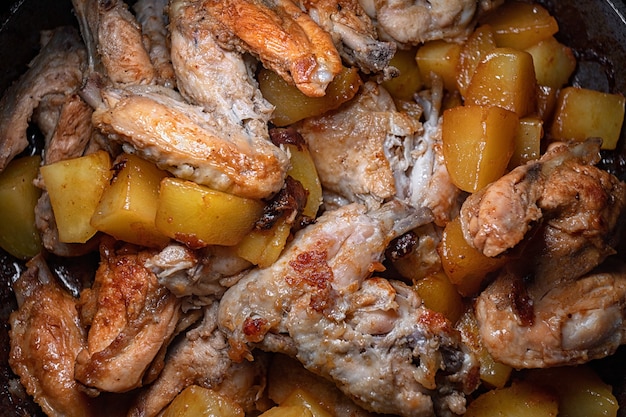 Fried Chicken Wings mit Kartoffeln werden in einer Pfanne gekocht, Nahaufnahme mit geringer Schärfentiefe