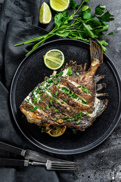 Fried Dory pescado con limón y perejil en una sartén. Comida sana vegatariana. Vista superior