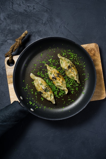 Fried japonés gyoza en una sartén.