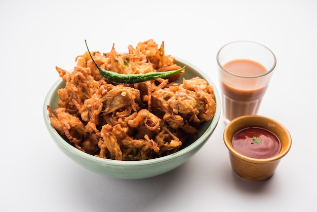 Fried Onion Pakora oder Pyaj Pakoda, auch bekannt als Crispy Kanda Bhaji / Bhajji / Bajji, beliebter indischer Snack zur Teezeit während der Regenzeit. serviert mit Tomatenketchup