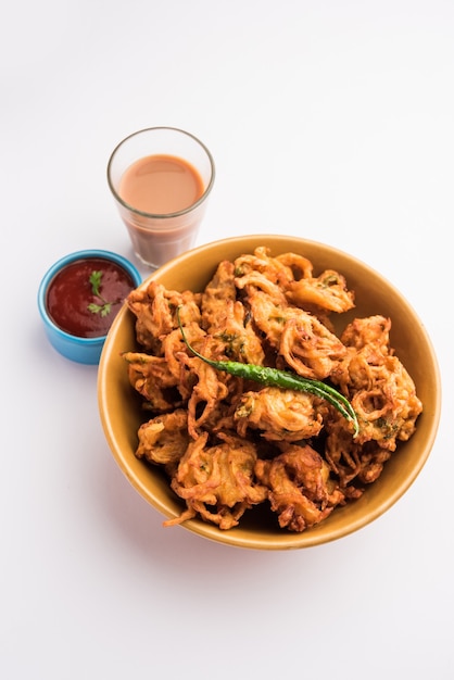 Fried Onion Pakora oder Pyaj Pakoda, auch bekannt als Crispy Kanda Bhaji / Bhajji / Bajji, beliebter indischer Snack zur Teezeit während der Regenzeit. serviert mit Tomatenketchup