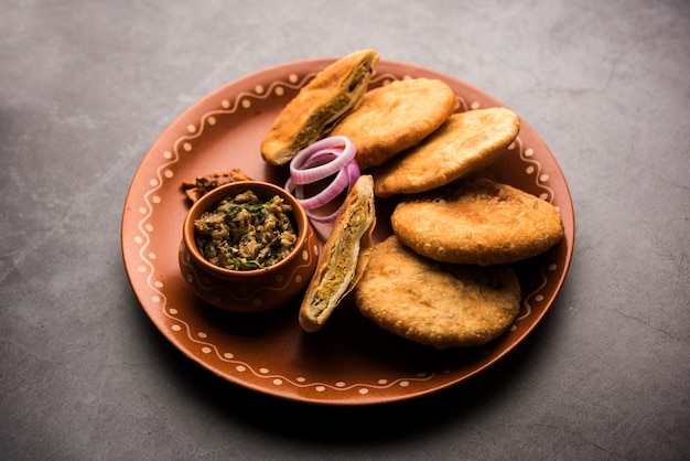 Fried Sattu Litti chokha servido com Baingan Bharta, cebola e picles, receita popular de Bihar, Índia