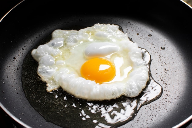 Fried sunny side up egg en una sartén caliente.