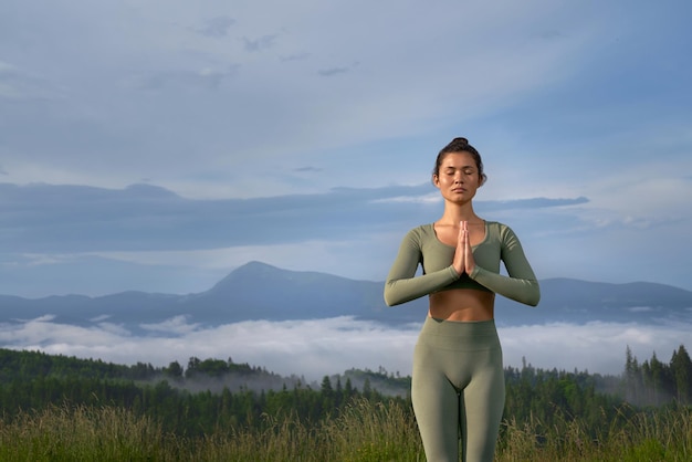 Friedliche Frau, die mit Blick auf die Berge meditiert