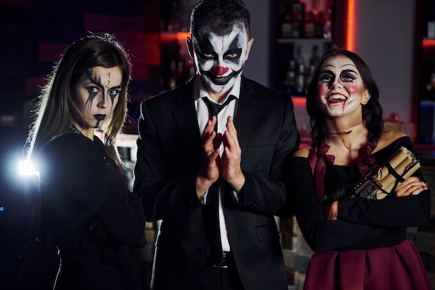 Friends está en la fiesta temática de Halloween con maquillaje aterrador y disfraces que se divierten y posan juntos para la cámara.